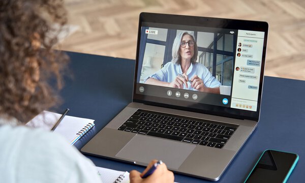 Frau am Laptop, Videokonferenz mit Chat auf dem Bildschirm sichtbar