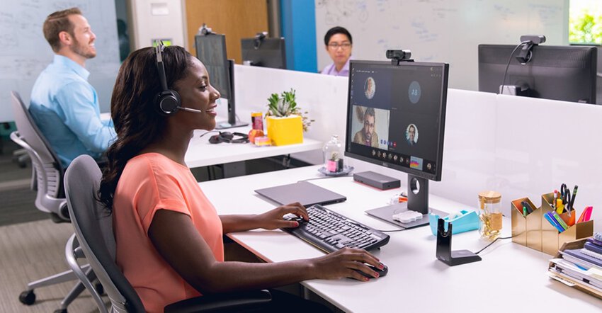 Eine Frau mit Headset die an ihrem Schreibtisch eine Videokonferenz mit Microsoft Teams abhält