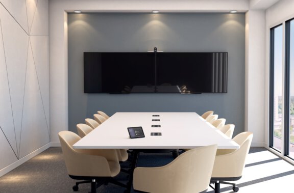 Ein leerer Konferenzraum, mit einem Tisch und doppeltem Display an der Wand, ein HP Poly E70 ist verbaut