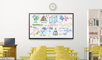 Ein leeres Klassenzimmer mit einem Samsung Flip 3 an der Wand, darüber befindet sich eine Uhr. Auf dem Whiteboard werden mathematische Formeln angezeigt. 